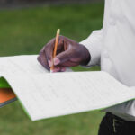 man holding notebooks writing