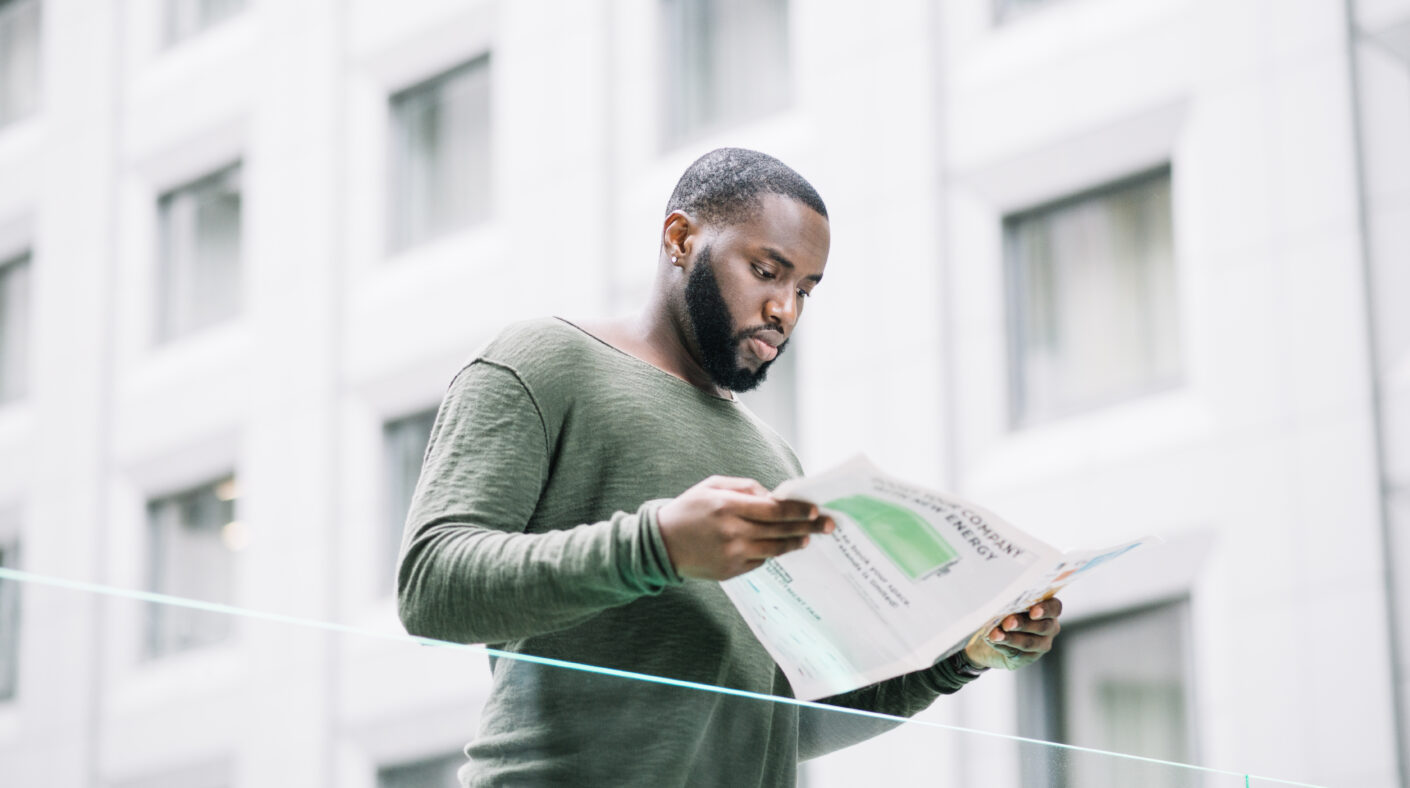 The 6-Month Difference: Why Buying Today Costs Less Than Waiting man reading newspaper near glass fence